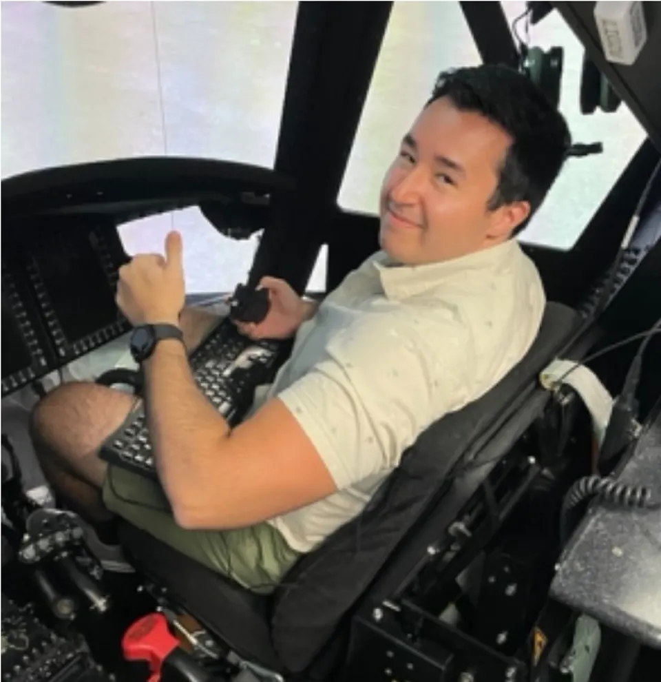 Andrew Apodaca giving a thumbs up from an aircraft cockpit